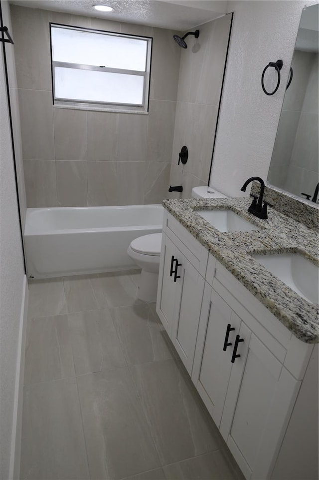 full bathroom with tiled shower / bath, vanity, and toilet