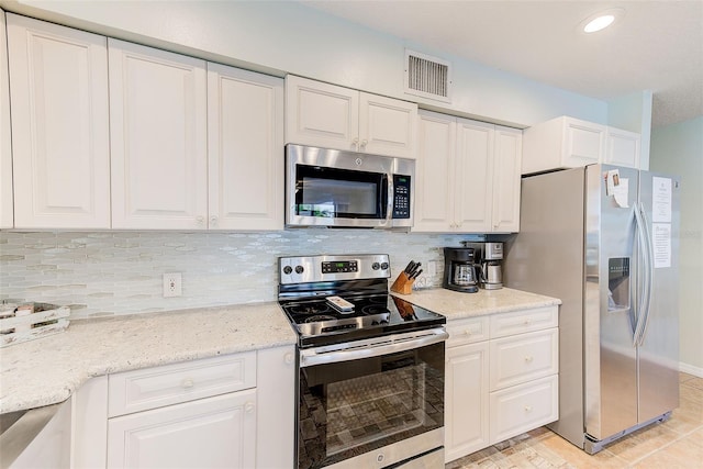 kitchen featuring light stone counters, visible vents, white cabinets, appliances with stainless steel finishes, and decorative backsplash