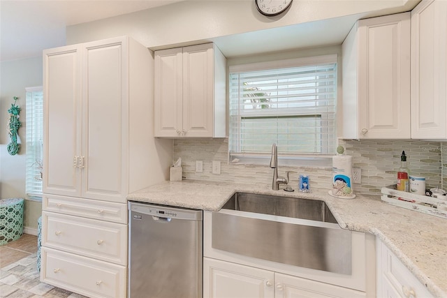 kitchen with a sink, tasteful backsplash, white cabinetry, and dishwasher