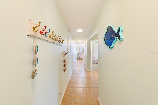 hallway with baseboards and light tile patterned floors