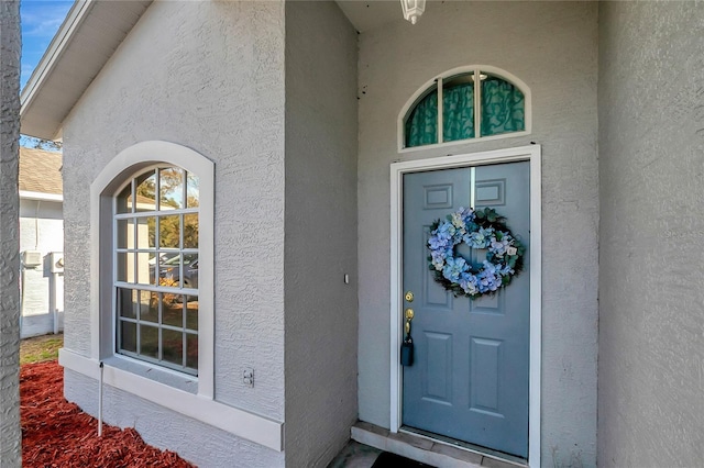 view of exterior entry featuring stucco siding