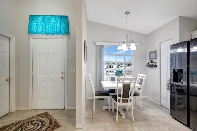 dining space with light tile patterned floors, baseboards, vaulted ceiling, and an inviting chandelier