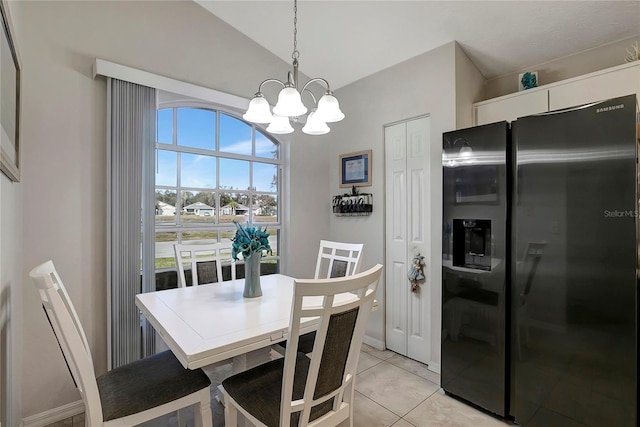 dining area featuring a notable chandelier, lofted ceiling, and light tile patterned floors