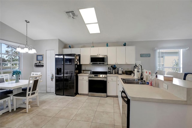 kitchen featuring light countertops, hanging light fixtures, white cabinets, a sink, and black appliances