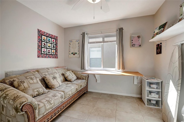 living area with a ceiling fan, baseboards, and light tile patterned floors