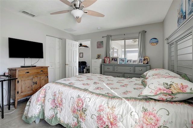 tiled bedroom featuring ceiling fan and a closet