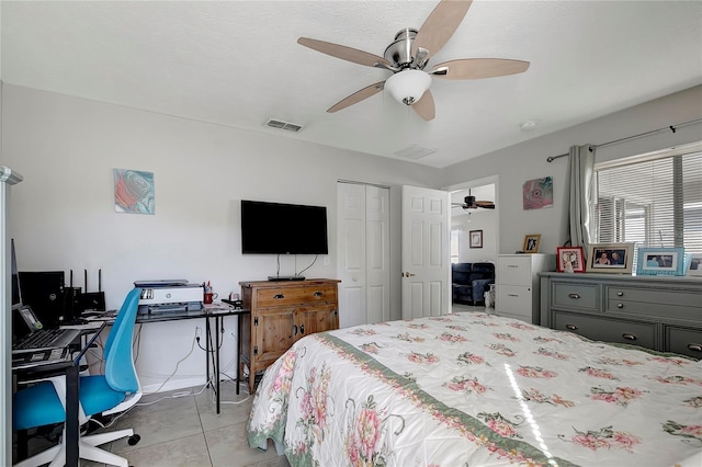 tiled bedroom with ceiling fan and a closet