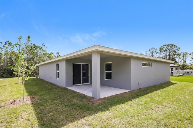 back of property with a yard and a patio