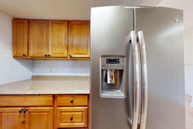 kitchen with stainless steel fridge with ice dispenser and backsplash