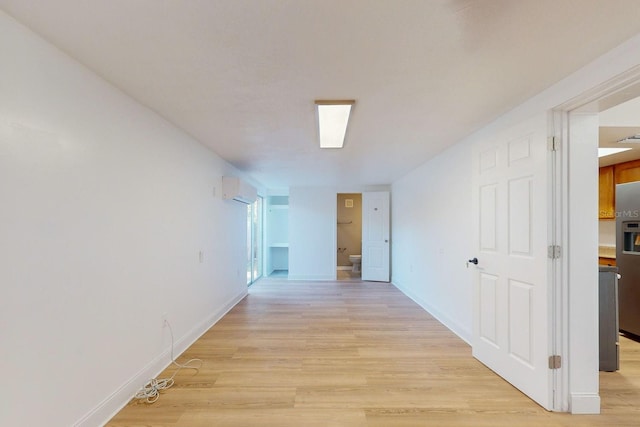 hall with a wall unit AC and light hardwood / wood-style floors