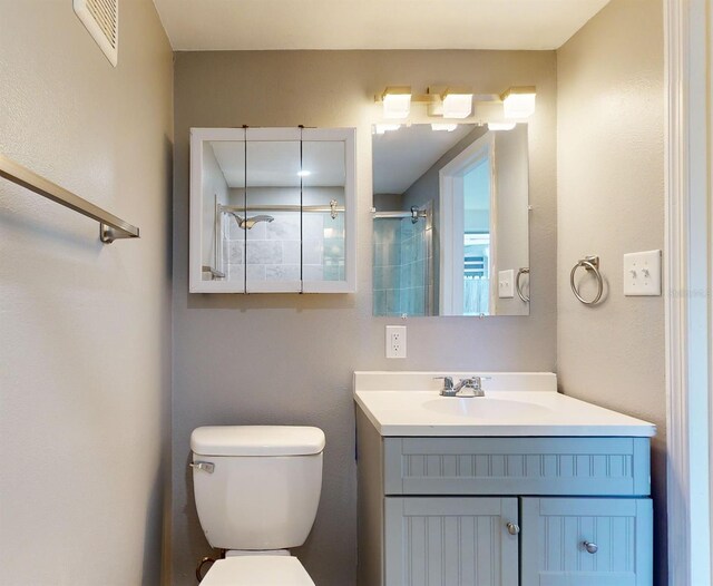 bathroom featuring vanity, a shower, and toilet