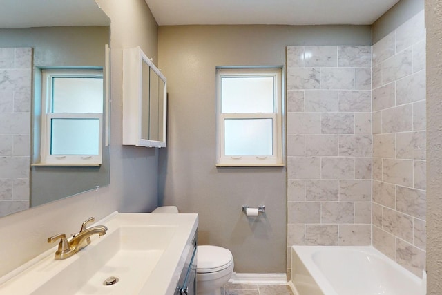 full bathroom with vanity, tiled shower / bath, and toilet