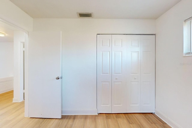 unfurnished bedroom featuring light hardwood / wood-style floors and a closet