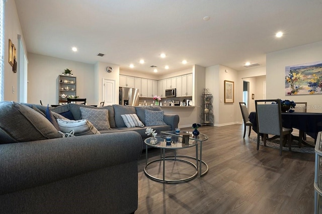 living area with baseboards, dark wood-type flooring, visible vents, and recessed lighting