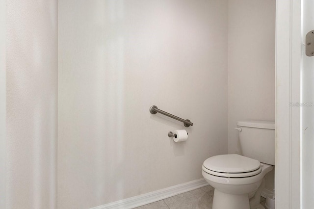 bathroom with baseboards, toilet, and tile patterned floors