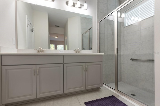 bathroom featuring a sink, double vanity, tile patterned flooring, and a shower stall