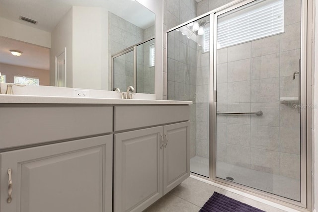 bathroom with a stall shower, visible vents, vanity, and tile patterned floors