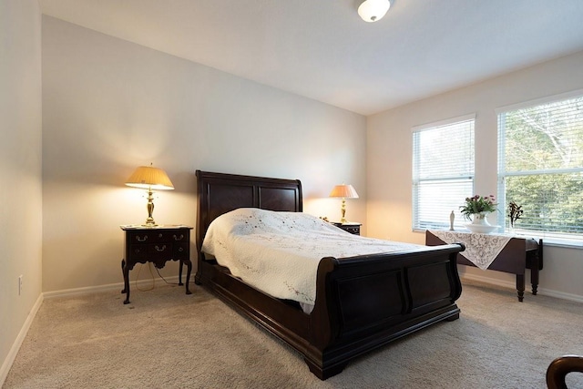 bedroom featuring light colored carpet and baseboards