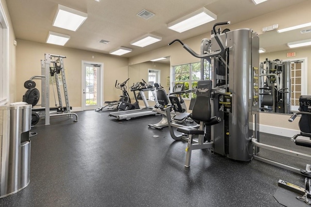 exercise room featuring plenty of natural light, visible vents, and baseboards