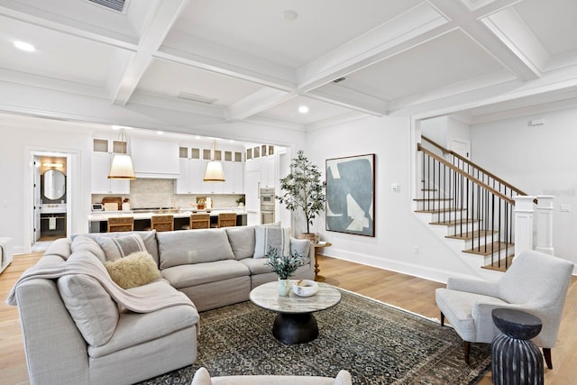 living room featuring coffered ceiling, beam ceiling, and light hardwood / wood-style flooring