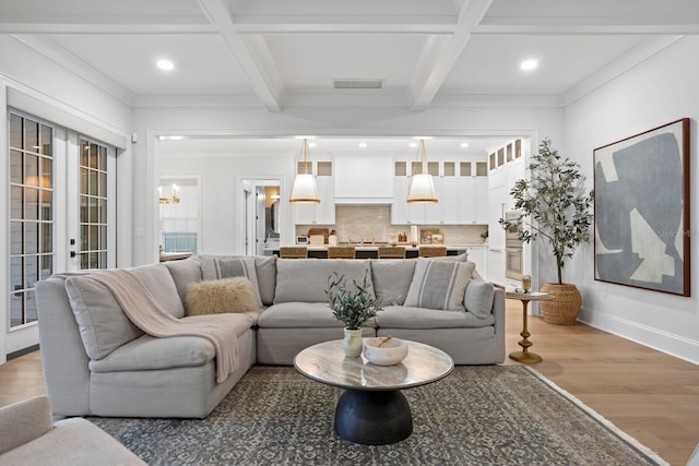 living room featuring coffered ceiling, wood-type flooring, french doors, and beamed ceiling