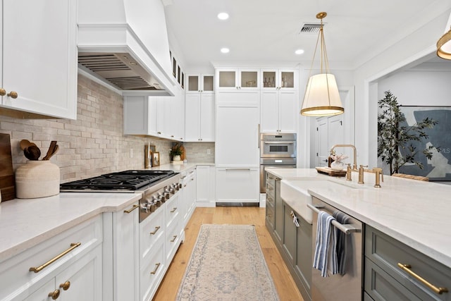 kitchen with custom exhaust hood, hanging light fixtures, gray cabinets, stainless steel appliances, and white cabinets