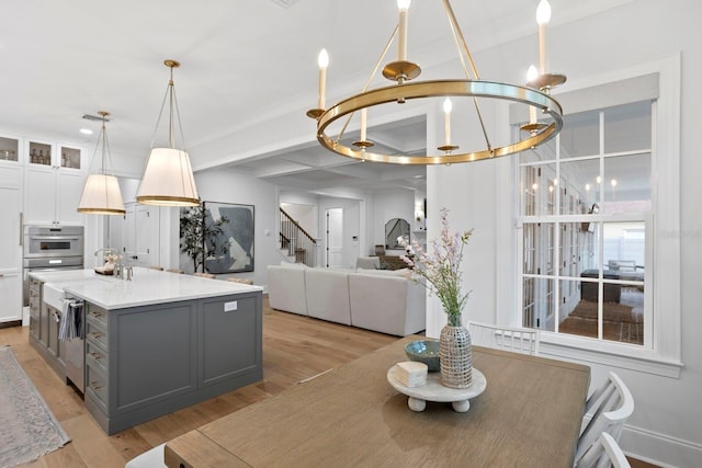 kitchen with white cabinetry, gray cabinets, light hardwood / wood-style floors, and a kitchen island