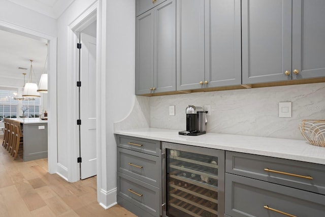 bar with beverage cooler and gray cabinetry