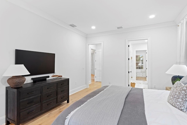 bedroom with crown molding, ensuite bath, and light hardwood / wood-style flooring