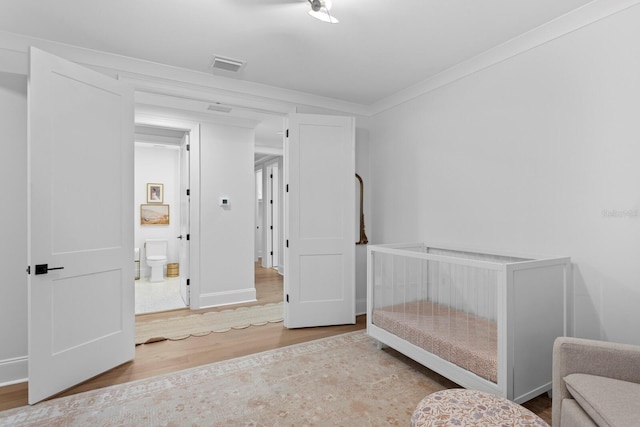 bedroom featuring hardwood / wood-style flooring and ornamental molding