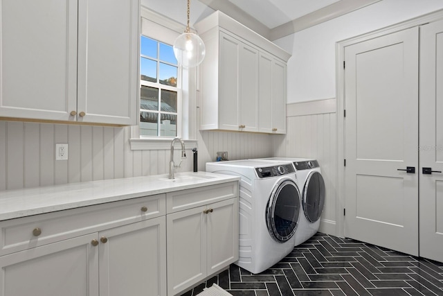 laundry room with cabinets, washing machine and dryer, and sink