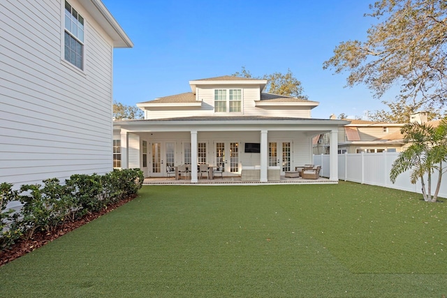 rear view of house with french doors and a yard