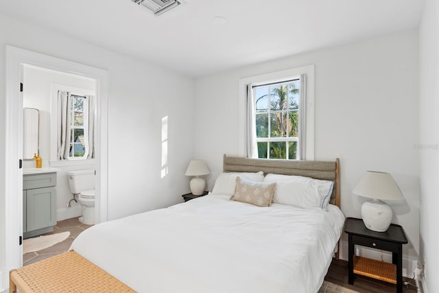 bedroom with light tile patterned flooring and ensuite bathroom