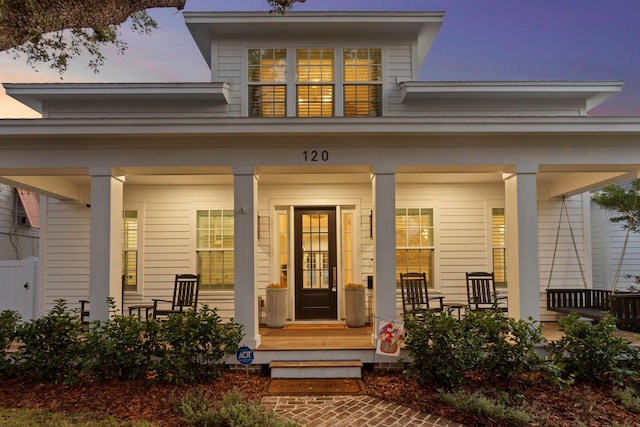 exterior entry at dusk featuring a porch