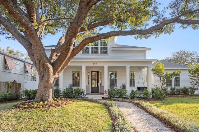 view of front of property with covered porch and a front lawn