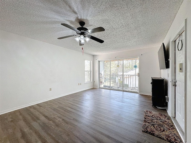 unfurnished living room with dark hardwood / wood-style flooring, ceiling fan, and a textured ceiling