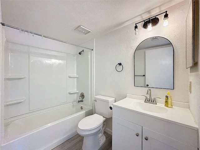 full bathroom with bathing tub / shower combination, hardwood / wood-style floors, vanity, a textured ceiling, and toilet