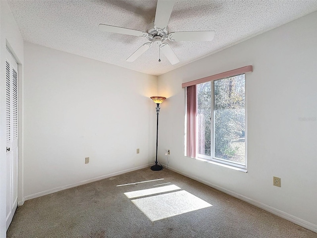 unfurnished room with ceiling fan, carpet flooring, and a textured ceiling