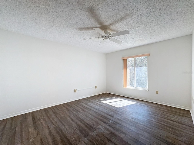 empty room with ceiling fan, dark hardwood / wood-style flooring, and a textured ceiling