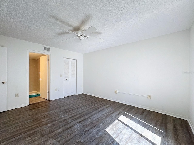 unfurnished bedroom featuring dark hardwood / wood-style floors, a textured ceiling, ceiling fan, and a closet