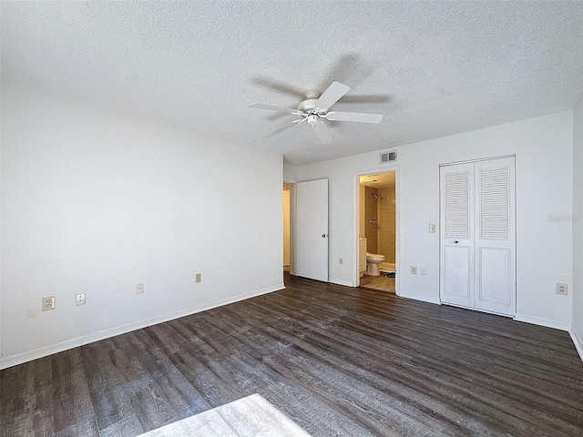 unfurnished bedroom with dark hardwood / wood-style flooring, a textured ceiling, ceiling fan, and ensuite bathroom