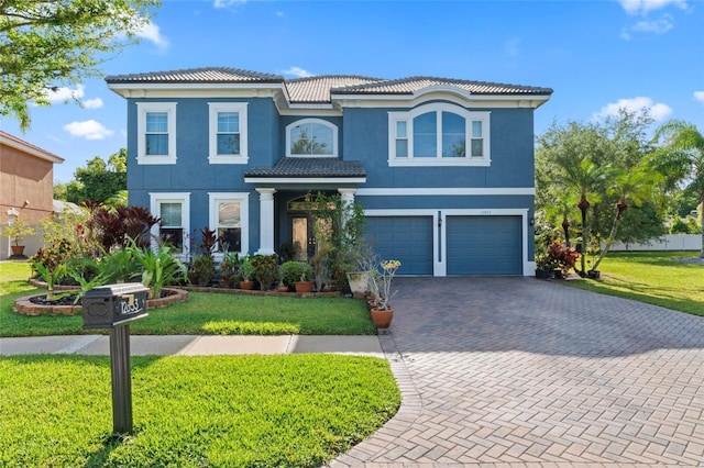 mediterranean / spanish home featuring a garage and a front yard