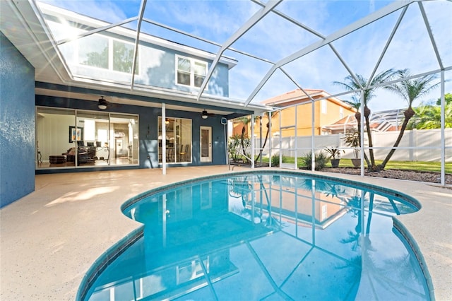 view of pool featuring a lanai, a patio area, and ceiling fan