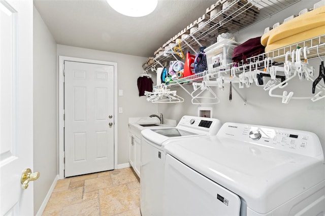 laundry area featuring cabinets, sink, and washer and dryer