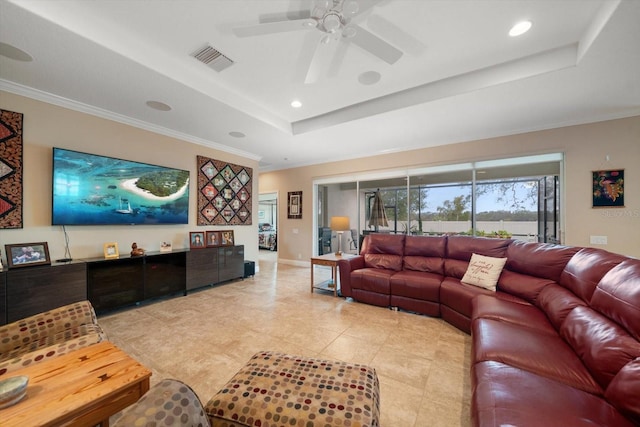 tiled living room featuring a tray ceiling, ornamental molding, and ceiling fan