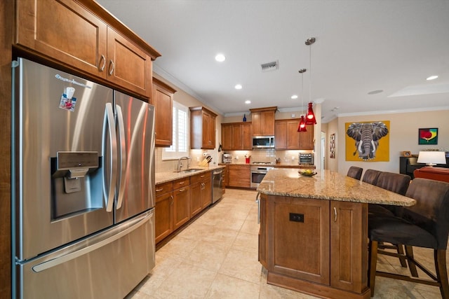 kitchen featuring pendant lighting, crown molding, a breakfast bar area, stainless steel appliances, and a kitchen island