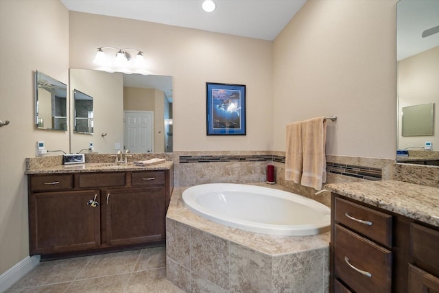 bathroom featuring tiled tub, vanity, and tile patterned floors