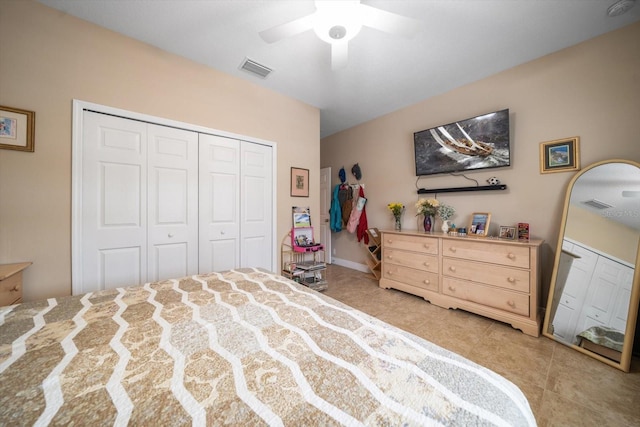 tiled bedroom featuring ceiling fan and a closet