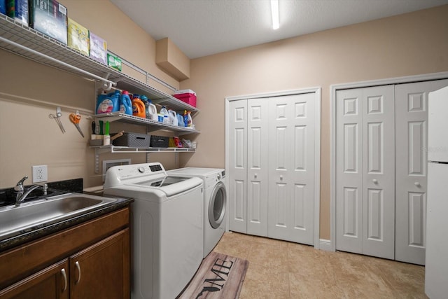 laundry area featuring cabinets, washing machine and dryer, sink, and light tile patterned flooring