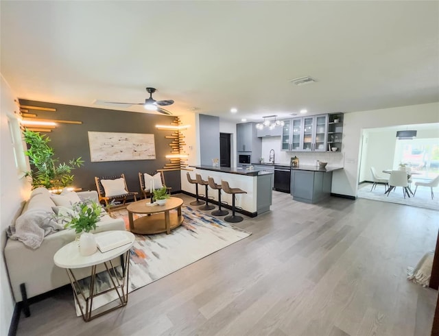 living area with ceiling fan, recessed lighting, visible vents, baseboards, and light wood finished floors